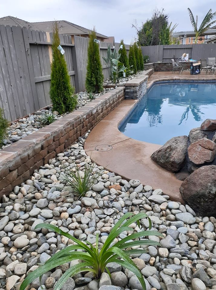 Finished stacked stone retaining walls and steps leading up to a front yard